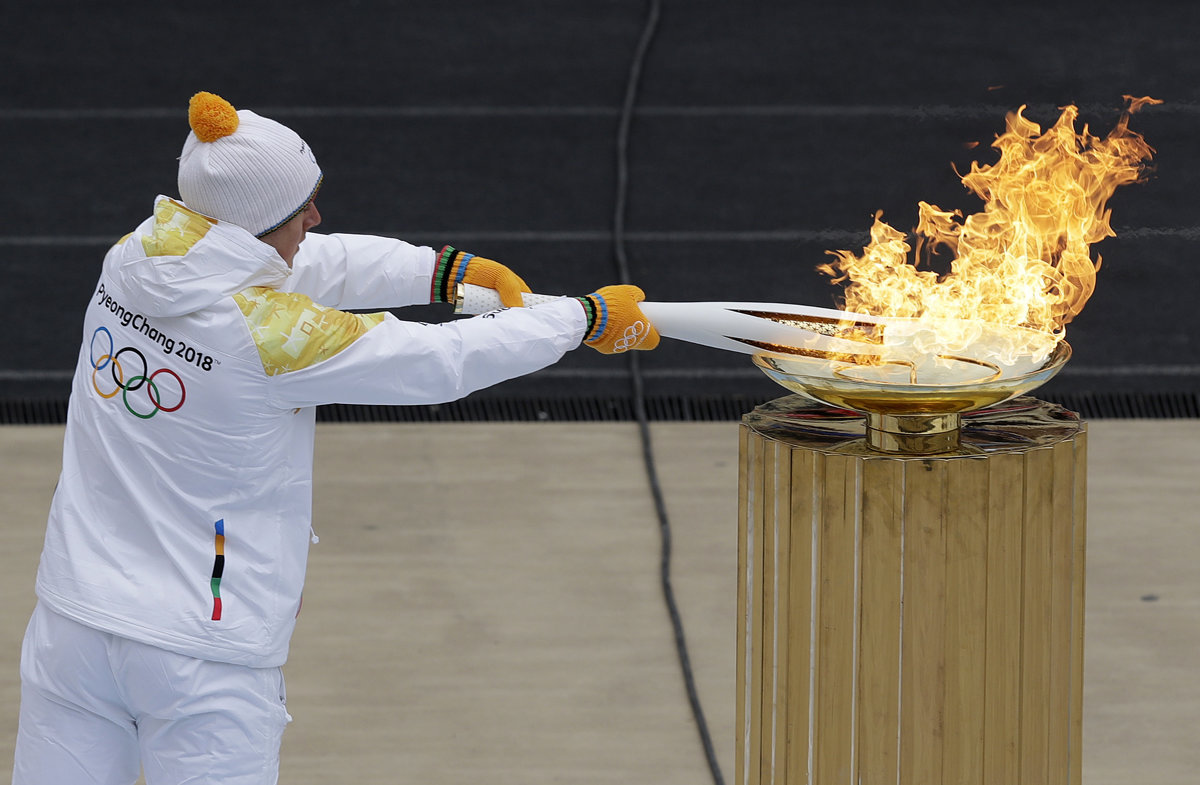 Факел начал игру. Олимпийский огонь на стадионе. Олимпийский огонь 2014. Факел олимпийского огня Олимпийских игр зажигается.